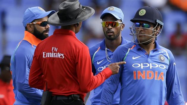 India's captain Virat Kohli, left, and MS Dhoni, right, talk to the umpire after West Indies' captain Jason Holder was dismissed during their third OD against West Indies.(AP)