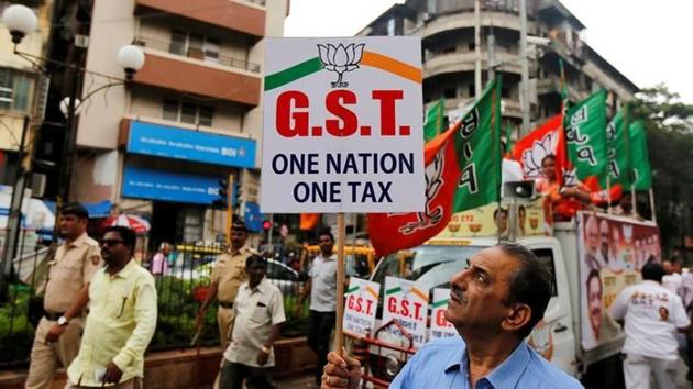A supporter of India's ruling Bharatiya Janata Party (BJP) holds a placard during a rally to support implementation of the Goods and Services Tax (GST) in Mumbai.(Reuters)