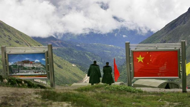 Chinese army officers oversee preparations as they stand between pictures of the Patola Palace and the Chinese flag, on the Chinese side of the international border at Nathula Pass, in Sikkim, on July 5, 2006.(AP File Photo) Chinese army officers oversee preparations as they stand between pictures of the Patola Palace and the Chinese flag, on the Chinese side of the international border at Nathula Pass, in Sikkim, on July 5, 2006.(AP File Photo)