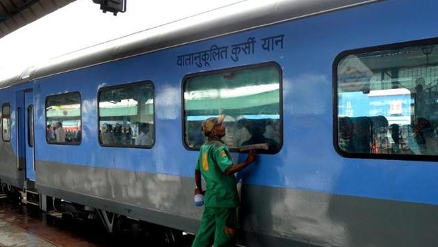 An Indian Railways worker cleans a coach at the New Delhi railway station.(AFP File Photo)