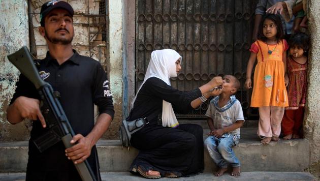 A Pakistani policeman stands guard as a health worker administers polio vaccine to a child during a vaccination campaign in Karachi in April 2017.(AFP File Photo / Representational) A Pakistani policeman stands guard as a health worker administers polio vaccine to a child during a vaccination campaign in Karachi in April 2017.(AFP File Photo / Representational)