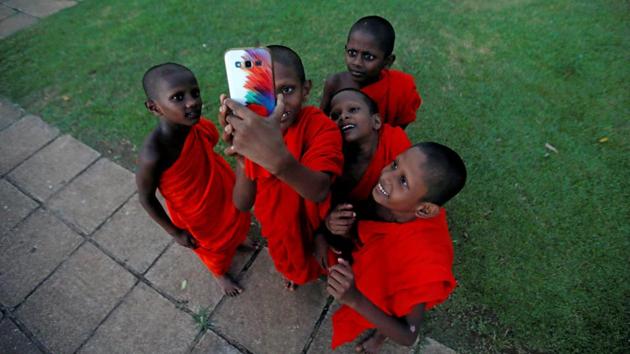 A group of novice Buddhist monks take selfies during a religious ceremony at a temple in Colombo, Sri Lanka. (Dinuka Liyanawatte / Reuters) A group of novice Buddhist monks take selfies during a religious ceremony at a temple in Colombo, Sri Lanka. (Dinuka Liyanawatte / Reuters)