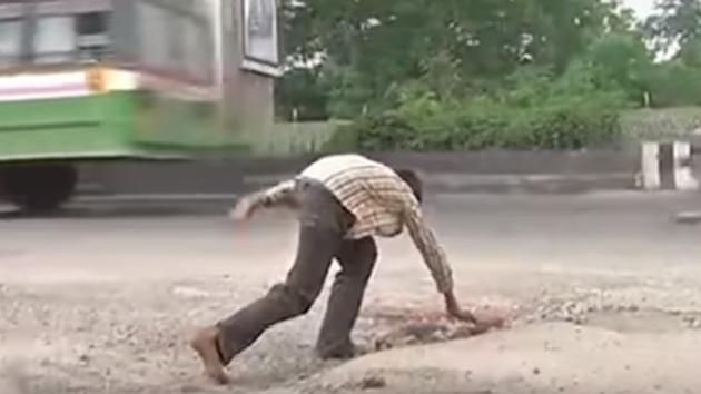 A screengrab of the Hyderabad teenager filling potholes with stones and gravels in Habsiguda area of the city.(ANI Photo)