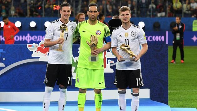 Germany's midfielder Julian Draxler holds the Golden Ball trophy, along side Chile's goalkeeper Claudio Bravo holding the Golden Glove trophy and Germany's forward Timo Werner holding the Golden Boot for best scorer award. (AFP) Germany's midfielder Julian Draxler holds the Golden Ball trophy, along side Chile's goalkeeper Claudio Bravo holding the Golden Glove trophy and Germany's forward Timo Werner holding the Golden Boot for best scorer award. (AFP)