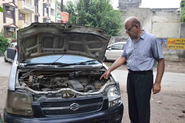 A Vaishali resident with one of the cars from which the battery was stolen on Sunday night.(Sakib Ali/HT Photo)