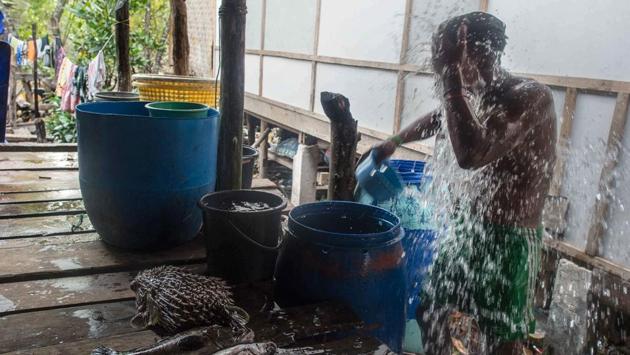 A fisherman bathes with fresh water after returning home from hunting for fish in Nyaung Wee village. (Ye Aung THU / AFP)