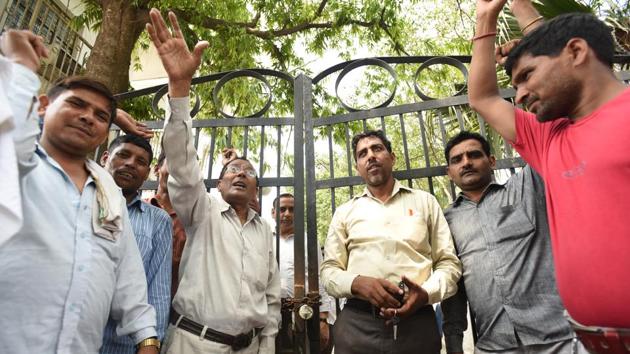 Workers demanding permanent jobs and better wages locked the gates of Noida authority’s offices in sectors 5, 19 and 39. However, the main office in Sector 6 was not affected.(Virendra Singh Gosain/HT Photo)