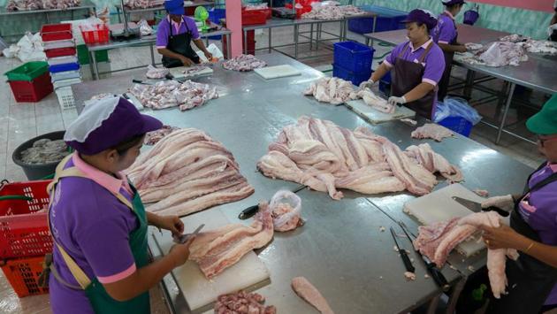 Workers process crocodile meat at a slaughterhouse on the outskirts of Bangkok. (Athit Perawongmetha / Reuters) 