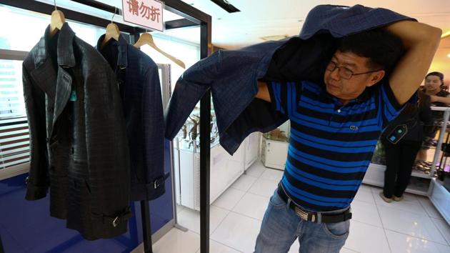 A Chinese tourist tries on a jacket made from crocodile skin at Sriracha Crocodile Farm in Chonburi province, Thailand. (Athit Perawongmetha / Reuters) 