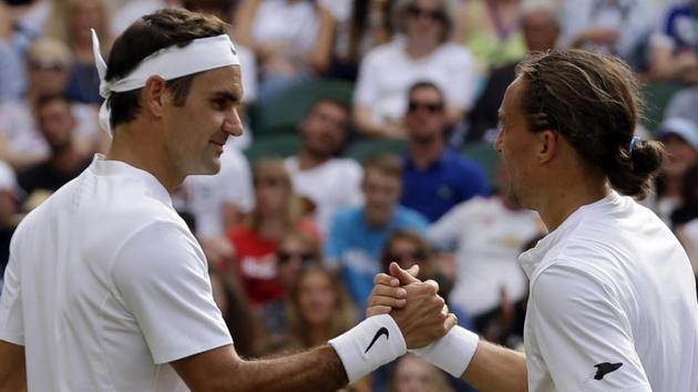 Roger Federer shakes hands with Alexandr Dolgopolov after winning their First Round match in Wimbledon. (AP)