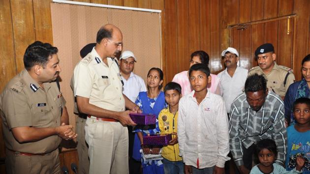 Director General of Police MA Ganpathy with some of the rescued children, in Dehradu on  Tuesday. (Vinay S Kumar/HT Photo)