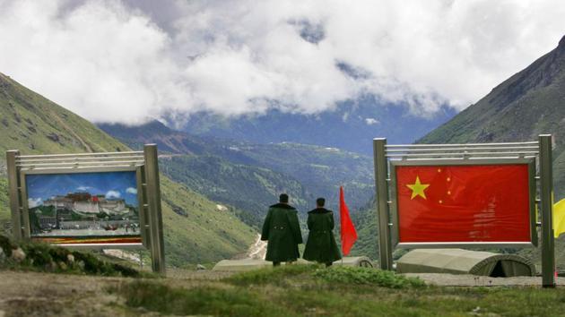 Nathu La - Indo-China Border - Chinese army officers oversee preparations as they stand between pictures of the Patola Palace, left, and the Chinese flag, on the Chinese side of the international border at Nathula Pass, in Sikkim. (AP Photo) Nathu La - Indo-China Border - Chinese army officers oversee preparations as they stand between pictures of the Patola Palace, left, and the Chinese flag, on the Chinese side of the international border at Nathula Pass, in Sikkim. (AP Photo)