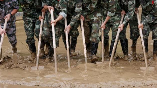 Paramilitary policemen sweep a flooded street in Guilin, Guangxi province. (REUTERS) Paramilitary policemen sweep a flooded street in Guilin, Guangxi province. (REUTERS)