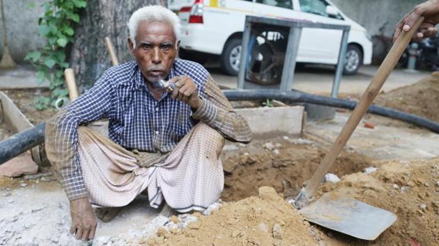 Meer Chand is a daily wager, we meet him while he is digging the pavement for underground cables to be installed.(Mayank Austen Soofi / HT Photo)