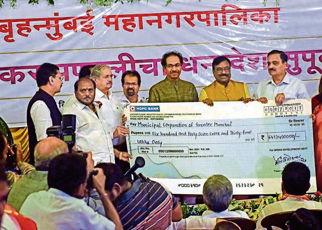 State finance minister Sudhir Mungantiwar (in yellow) handed over a Rs647.34-crore cheque — the first of many payments compensating the civic body for its post-GST octroi loss — at BMC headquarters on Wednesday. (Pratik Chorge/HT Photo) State finance minister Sudhir Mungantiwar (in yellow) handed over a Rs647.34-crore cheque — the first of many payments compensating the civic body for its post-GST octroi loss — at BMC headquarters on Wednesday. (Pratik Chorge/HT Photo)