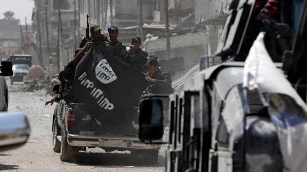 Iraqi Federal Police members hold an Islamic State flag which they pulled down during fighting between Iraqi forces and Islamic State militants in the Old City of Mosul. (Ahmed Saad / Reuters)