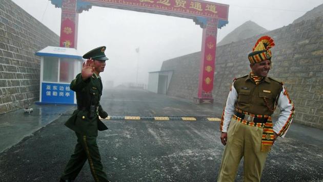 This file photo taken on July 10, 2008 shows a Chinese soldier (L) next to an Indian soldier at the Nathu La border crossing between India and China in Sikkim.(AFP File Photo)