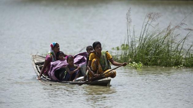 An woman with her family and her belongings paddles a boat through flood waters at Khola Bhuyan village, east of Guwahati, Assam, July 5, 2017. (AP) An woman with her family and her belongings paddles a boat through flood waters at Khola Bhuyan village, east of Guwahati, Assam, July 5, 2017. (AP)