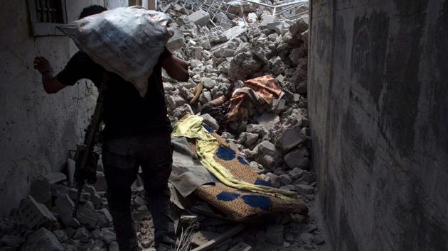 Iraqi Counter-Terrorism Service (CTS) walk past a body as they make their way through an alley. (AFP)