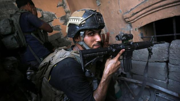 Iraqi Counter-Terrorism Service (CTS) take position inside a house in the Maidan district. Clashes have displaced more than 850,000 people, according to the International Organization for Migration. (AFP)