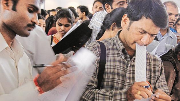People fill out forms at a job fair.