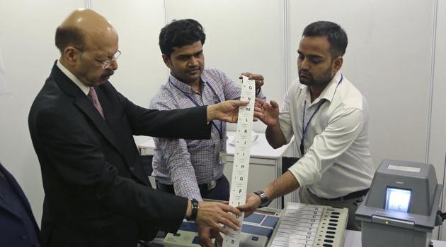 Election Commission head Nasim Zaidi, left, inspects an electronic voting machine in New Delhi on May 20.(AP Photo)