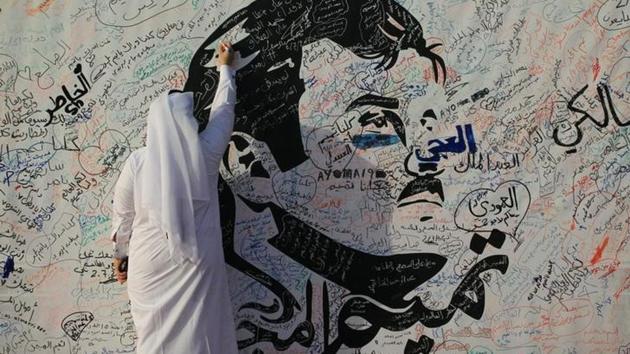 A man writes on a painting depicting Qatar’s Emir Sheikh Tamim Bin Hamad Al-Thani in Doha. (Reuters) A man writes on a painting depicting Qatar’s Emir Sheikh Tamim Bin Hamad Al-Thani in Doha. (Reuters)