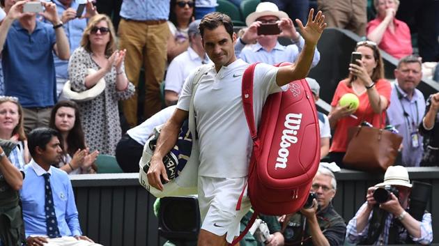 Roger Federer waves as he leaves the court after Ukraine's Alexandr Dolgopolov retired during their men's singles first round match on the second day of the 2017 Wimbledon Championships.(AFP)