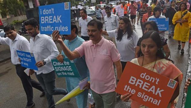 Residents took part in a walkathon organised by an NGO to create awareness on road safety in Baner.(HT Photo)