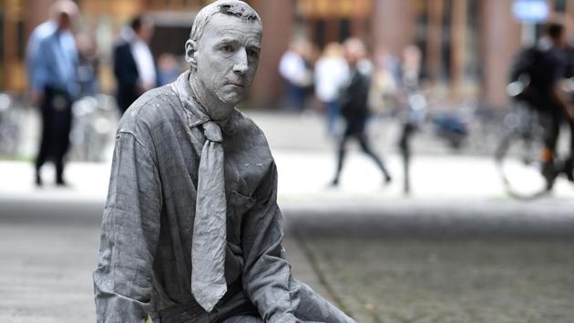 A performers smeared with clay demonstrates during the art action "1000 Gestalten" (1000 figures). (Christof Stache / AFP)