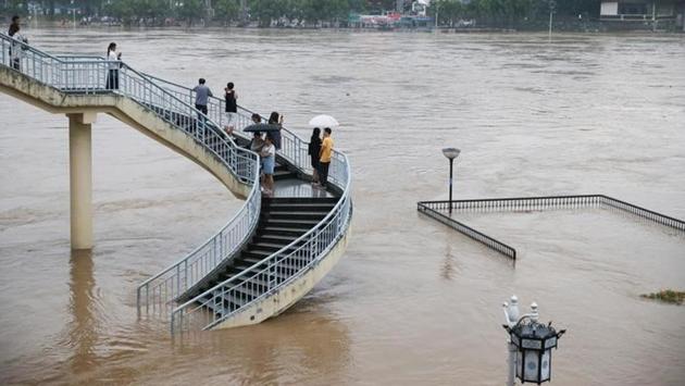 People watch the rising water level of the Li River during a flood in Guilin, Guangxi Zhuang Autonomous Region, China. (REUTERS) People watch the rising water level of the Li River during a flood in Guilin, Guangxi Zhuang Autonomous Region, China. (REUTERS)
