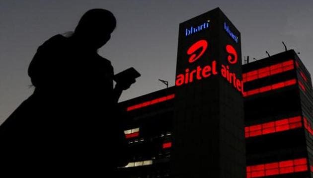 A girl checks her mobile phone as she walks past the Bharti Airtel office building. (Reuters File Photo) A girl checks her mobile phone as she walks past the Bharti Airtel office building. (Reuters File Photo)