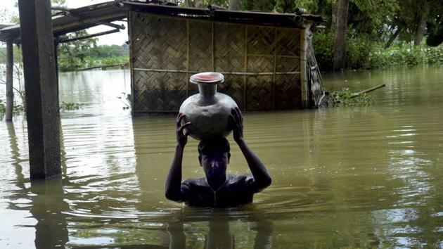 A boy carries fresh drinking water on head as he wades through flooded water at Padder parr village in Karimganj district, Assam. (PTI) A boy carries fresh drinking water on head as he wades through flooded water at Padder parr village in Karimganj district, Assam. (PTI)