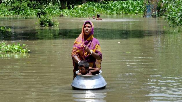 A woman with her child, in a utensil, moves to a safer place from the flood affected Khanamukh village in Morigoan, Assam. Several rivers are in spate across the northeastern state. According to the Assam State Disaster Management Authority reports, the current flood claimed 19 lives, affected four lakh people across 15 districts. (PTI)