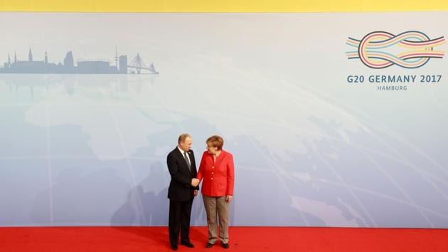 German Chancellor Angela Merkel welcomes Russia's President Vladimir Putin as he arrives for the summit in Germany. (AFP)