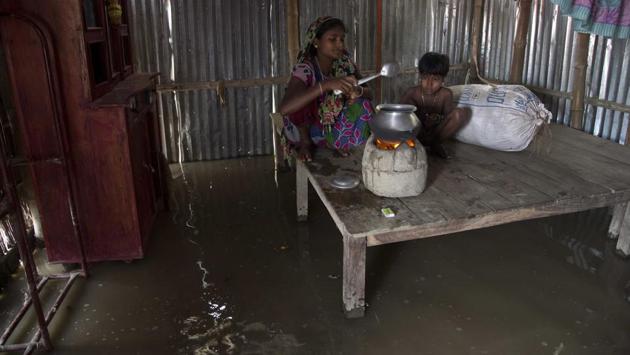 A woman prepares food in her flooded house in Burgaon, 80 kilometers (50 miles) east of Gauhati. The water levels of Brahmaputra river and its tributaries crossed danger level mark at several areas in the state caused by incessant rains in past couple of days. (Anupam Nath / AP)