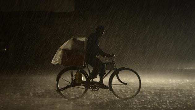A man rides on a bike as heavy rain falls in Jalandhar. (AFP) A man rides on a bike as heavy rain falls in Jalandhar. (AFP)
