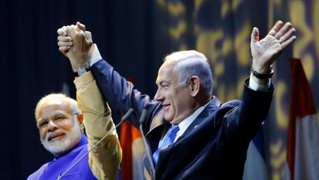 Israeli Prime Minister Benjamin Netanyahu (R) holds hands with his Indian counterpart Narendra Modi during a meeting with Indian community in the Israeli coastal city of Tel Aviv, on July 5, 2017. Prime Minister Narendra Modi arrived in Israel for what he called a "groundbreaking" first ever visit by an Indian premier, with growing ties between the two countries including billion of dollars in defence deals. / AFP PHOTO / GIL COHEN-MAGEN (AFP) Israeli Prime Minister Benjamin Netanyahu (R) holds hands with his Indian counterpart Narendra Modi during a meeting with Indian community in the Israeli coastal city of Tel Aviv, on July 5, 2017. Prime Minister Narendra Modi arrived in Israel for what he called a "groundbreaking" first ever visit by an Indian premier, with growing ties between the two countries including billion of dollars in defence deals. / AFP PHOTO / GIL COHEN-MAGEN (AFP)