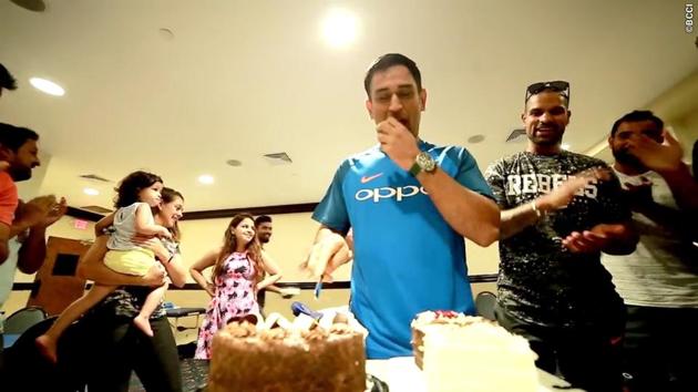 Dhoni is wished by team-mates as he cuts the cake.  (BCCI) 