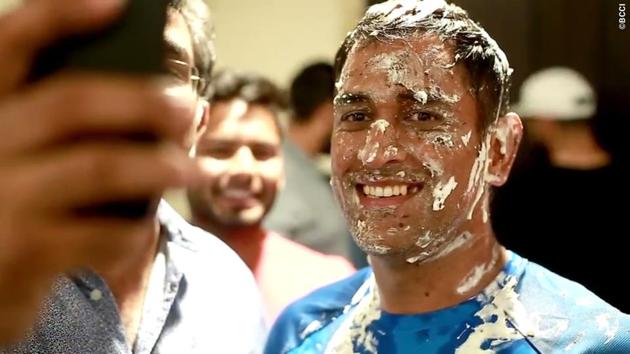 Dhoni poses for another picture despite his face being smeared with cake.  (BCCI) 