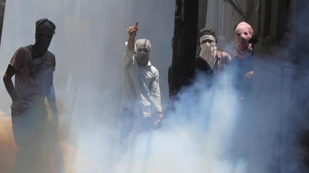 A group of protesters in Srinagar amid tear gas fired by police during clashes in Srinagar on Saturday as the authorities imposed curfew on the first death anniversary of Hizbul  militant Burhan Wani. (Waseem Andrabi / HT Photo)