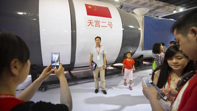 Visitors pose for photos in front of a full-size replica of China's Tiangong-2 space station at the China Beijing International High-Tech Expo in Beijing, Saturday, June 10, 2017. (AP) Visitors pose for photos in front of a full-size replica of China's Tiangong-2 space station at the China Beijing International High-Tech Expo in Beijing, Saturday, June 10, 2017. (AP)