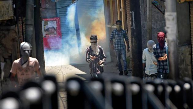 Protesters throw stones at security forces amid bursting of tear gas shell during clashes between security forces and protesters on the first death anniversary of Hizbul Mujahideen commander Burhan Wani, in Srinagar on July 8. (PTI Photo) Protesters throw stones at security forces amid bursting of tear gas shell during clashes between security forces and protesters on the first death anniversary of Hizbul Mujahideen commander Burhan Wani, in Srinagar on July 8. (PTI Photo)