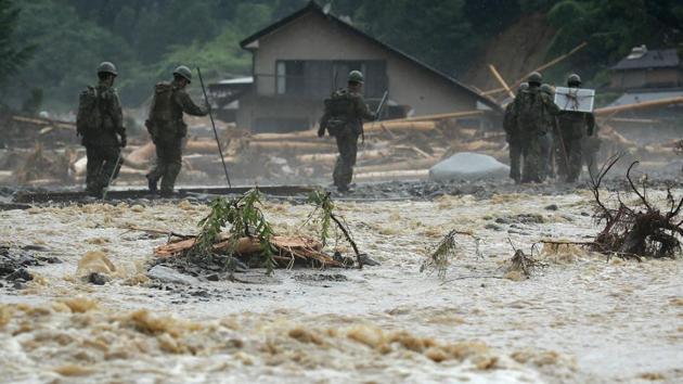 Defense forces soldiers walk beside a river during a search operation for missing people in a flooded area in Asakura on July 9, 2017. (AFP) Defense forces soldiers walk beside a river during a search operation for missing people in a flooded area in Asakura on July 9, 2017. (AFP)