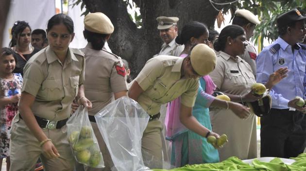 Punjab Police personnel grabbing mangoes from display at 26th Mango Mela at Pinjore Garden on Sunday. (Sant Arora/HT Photo)