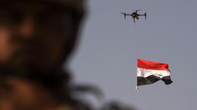 Iraq's national flag is suspended to a drone of Iraq's federal police as forces celebrate in the Old City of Mosul. (FADEL SENNA / AFP) Iraq's national flag is suspended to a drone of Iraq's federal police as forces celebrate in the Old City of Mosul. (FADEL SENNA / AFP)