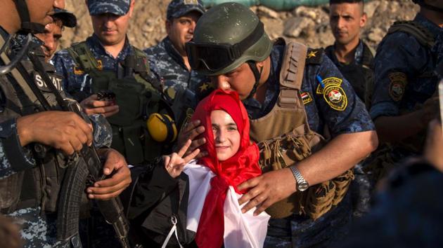 A member of Iraq's federal police kisses a girl as forces celebrate in the Old City of Mosul . The victory marked the formal end of a bloody battle that lasted nearly nine months, left much of Iraq’s second-largest city in ruins, killed thousands of people and displaced nearly a million more. (FADEL SENNA / AFP) A member of Iraq's federal police kisses a girl as forces celebrate in the Old City of Mosul . The victory marked the formal end of a bloody battle that lasted nearly nine months, left much of Iraq’s second-largest city in ruins, killed thousands of people and displaced nearly a million more. (FADEL SENNA / AFP)