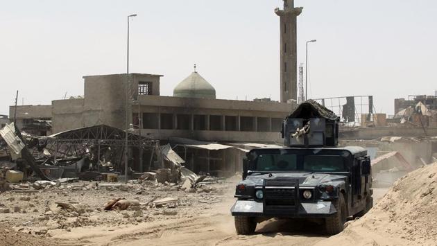 Iraqi forces drive their vehicle past a mosque in Mosul's Old City. The nearly nine-month battle for Mosul has ruined parts of the city, killed thousands of civilians and displaced nearly one million. (AHMAD AL-RUBAYE / AFP) Iraqi forces drive their vehicle past a mosque in Mosul's Old City. The nearly nine-month battle for Mosul has ruined parts of the city, killed thousands of civilians and displaced nearly one million. (AHMAD AL-RUBAYE / AFP)