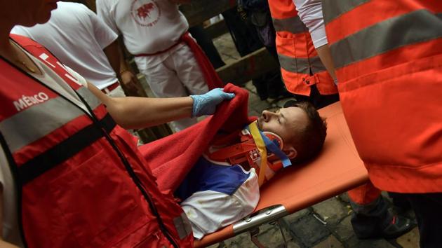 An injured man is taken on a stretcher during the running of the bulls at the San Fermin Festival, in Pamplona, northern Spain, Monday, July 10, 2017. So far, two people suffered minor injuries but none were gored on Monday on the fourth day of the San Fermin festival where a dozen bulls chase hundreds of people dressed in white with red neckerchiefs through the streets of Pamplona in northern Spain. (Alvaro Barrientos / AP) An injured man is taken on a stretcher during the running of the bulls at the San Fermin Festival, in Pamplona, northern Spain, Monday, July 10, 2017. So far, two people suffered minor injuries but none were gored on Monday on the fourth day of the San Fermin festival where a dozen bulls chase hundreds of people dressed in white with red neckerchiefs through the streets of Pamplona in northern Spain. (Alvaro Barrientos / AP)
