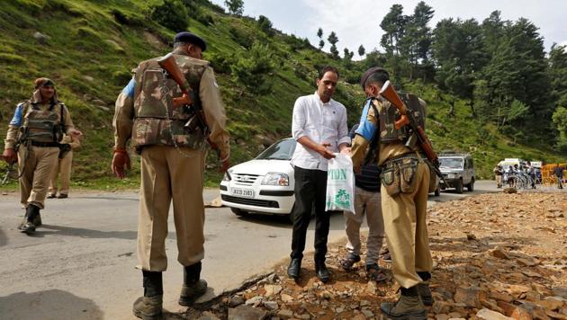 A security force personnel (R) checks the bag of a man near a base camp of Hindu pilgrimage to the cave of Amarnath after seven Hindu pilgrims were killed in a gunbattle between Indian police and militants on Monday.(REUTERS)